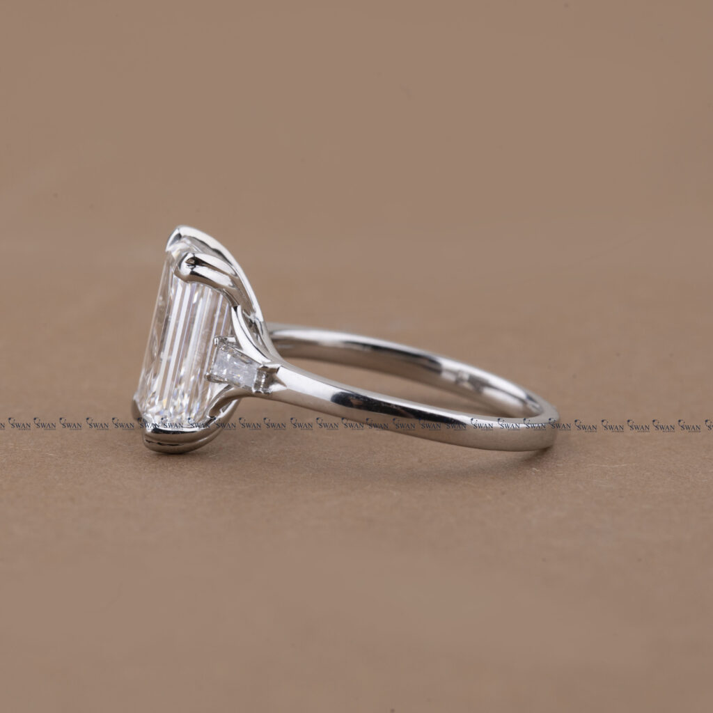 Three Stone Emerald Cut Lab Grown Diamond Engagement Ring With Unique Heart Prong Side Baguette Diamond